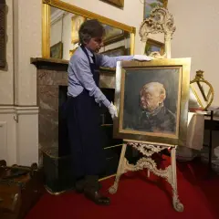 Un homme présente un portrait de Churchill par Graham Sutherland, une œuvre d'art saisissante.