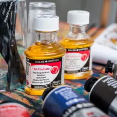 Pinceaux et flacons d'huile médium Daler Rowney sur une palette colorée. Pour commencer une peinture, on peut choisir de travailler le clair ou le foncé.
