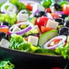 Salade grecque colorée avec feta, olives noires, tomates, oignons rouges et concombre. Un plat qui invite à raconter des salades, avec une origine qui remonte à l'Antiquité.