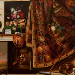 Un célèbre tableau trompe l'oeil présente un atelier d'artiste avec des fruits, des fleurs, une palette, des toiles et un tapis orné.