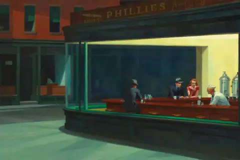 Nuit d'Edward Hopper : des clients isolés dans un diner éclairé la nuit, une scène emblématique de la solitude urbaine.