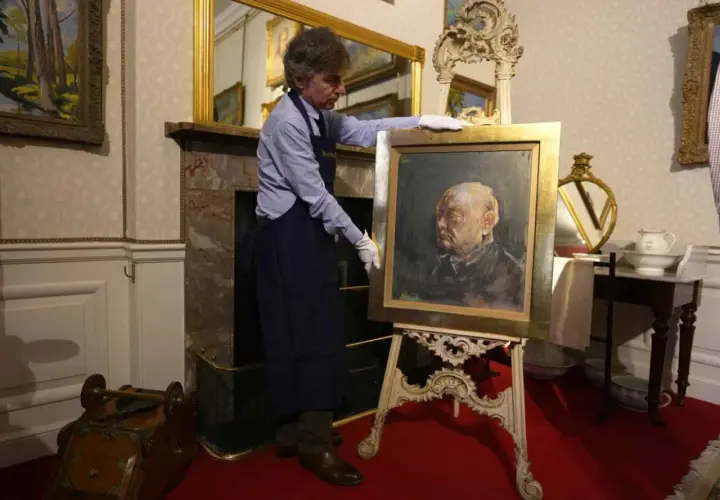 Un homme présente un portrait de Churchill par Graham Sutherland, une œuvre d'art saisissante.
