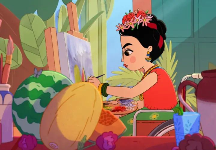 Frida Kahlo jeune, assise dans son fauteuil, peint un tableau coloré entourée de fruits et de fleurs.