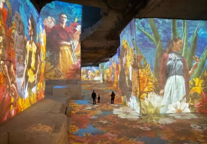 Immersion dans un univers floral et coloré, où les portraits de Frida Kahlo se mêlent à un **plein vide** d'art projeté sur les murs et le sol.