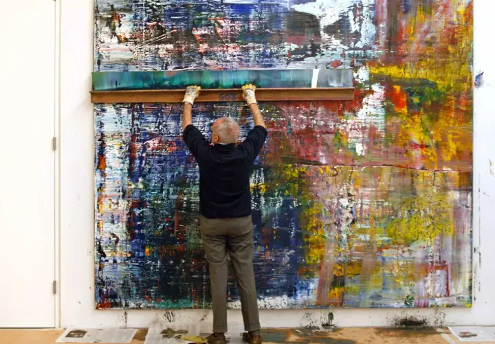 Gerhard Richter utilise une raclette sur une toile abstraite aux couleurs vives.