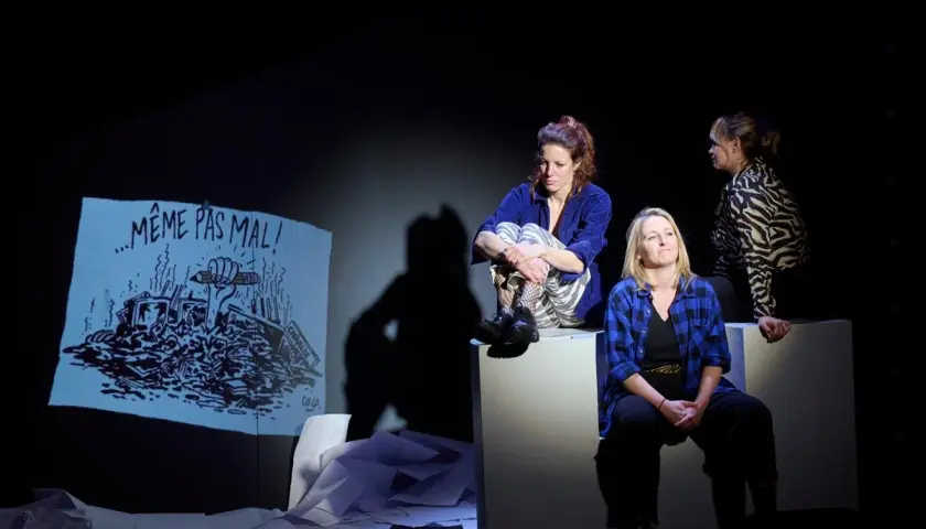 Trois femmes sur scène, une projection d'un dessin "Même pas mal !" dessiner à partir d'une photo.