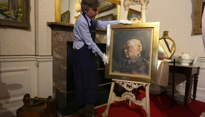 Un homme présente un portrait de Churchill par Graham Sutherland, une œuvre d'art saisissante.