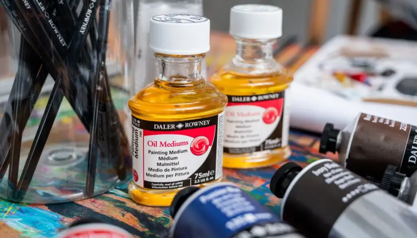 Pinceaux et flacons d'huile médium Daler Rowney sur une palette colorée. Pour commencer une peinture, on peut choisir de travailler le clair ou le foncé.