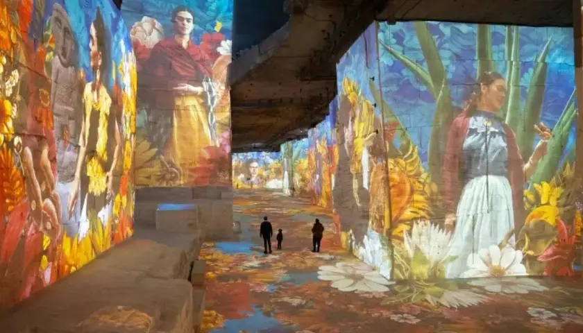 Immersion dans un univers floral et coloré, où les portraits de Frida Kahlo se mêlent à un **plein vide** d'art projeté sur les murs et le sol.