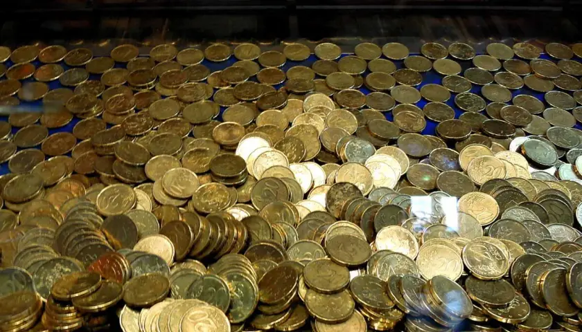 Un tas de pièces d'or, un véritable pactole, s'entassent dans une machine à sous, promettant fortune et gloire.