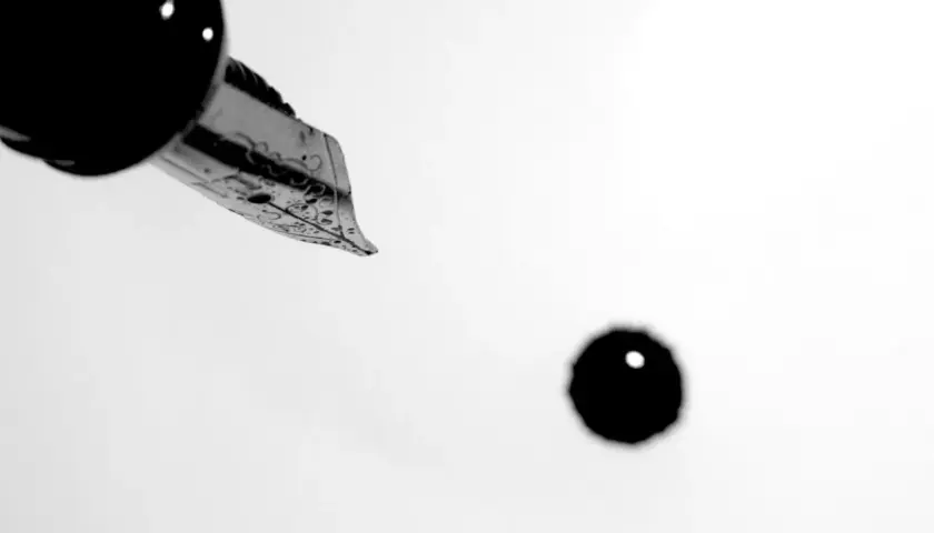 Plume d'une plume d'encre ornée, prête à écrire. Une goutte d'encre tombe, faisant se faire un sang d'encre pour le résultat.