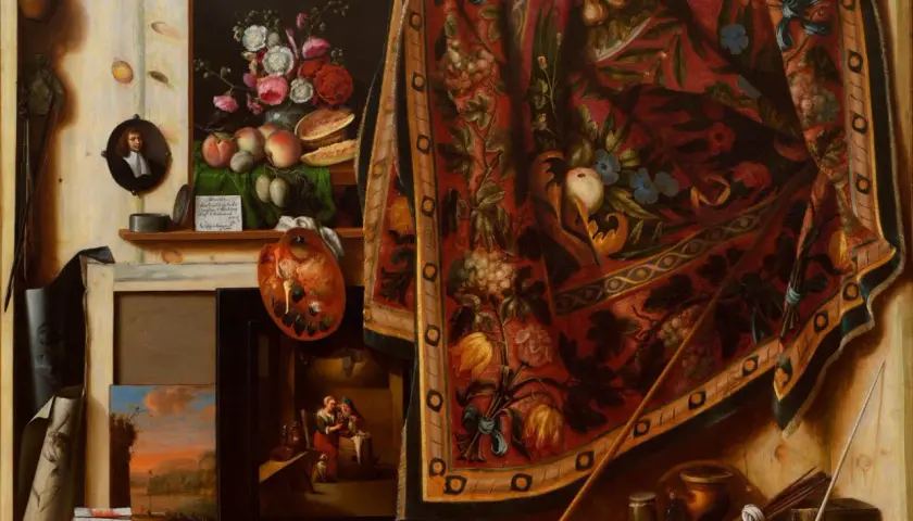 Un célèbre tableau trompe l'oeil présente un atelier d'artiste avec des fruits, des fleurs, une palette, des toiles et un tapis orné.