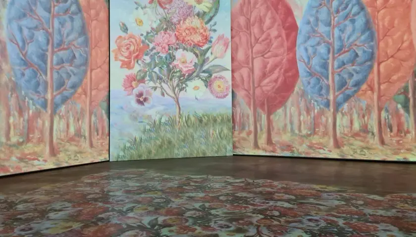 Installation d'art avec des arbres stylisés et un bouquet de fleurs, évoquant l'univers d'un peintre belge. Le sol est orné d'un motif floral projeté.
