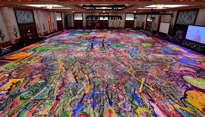 Un immense tableau, "la création du monde", recouvre le sol d'une salle. Des éclaboussures de peinture vives créent un chaos coloré, évoquant l'énergie primordiale.