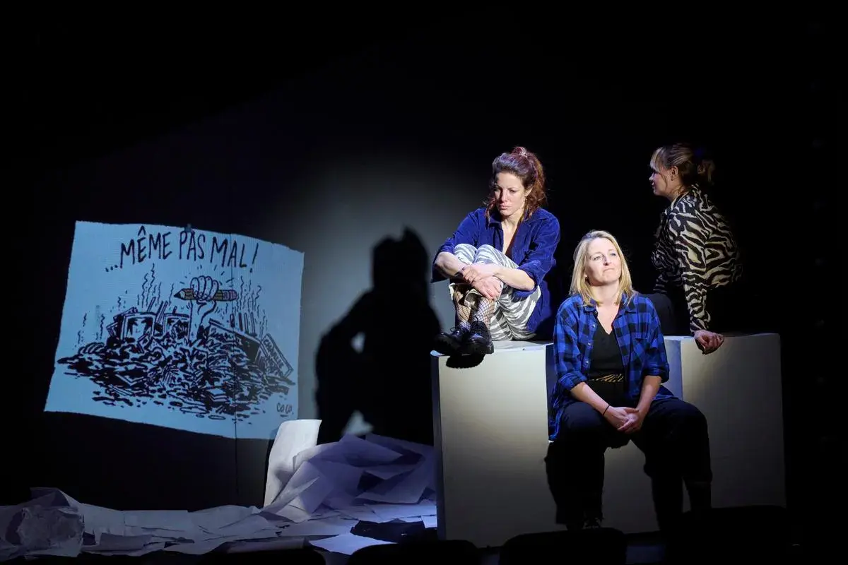 Trois femmes sur scène, une projection d'un dessin "Même pas mal !" dessiner à partir d'une photo.