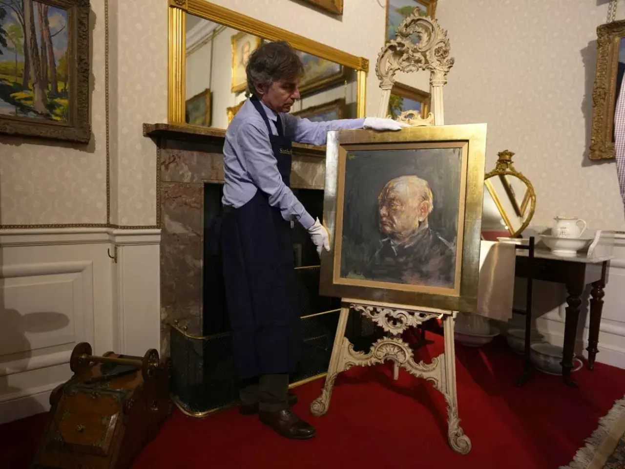 Un homme présente un portrait de Churchill par Graham Sutherland, une œuvre d'art saisissante.