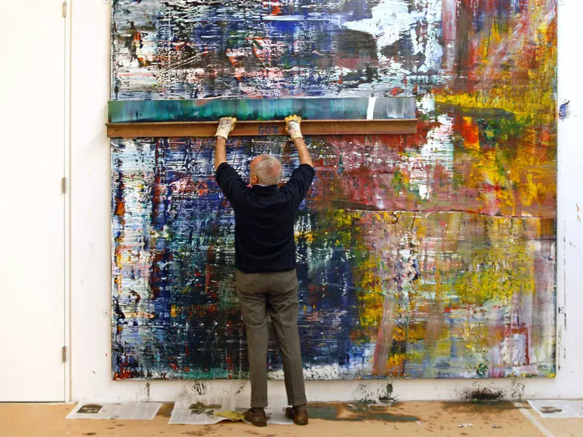 Gerhard Richter utilise une raclette sur une toile abstraite aux couleurs vives.