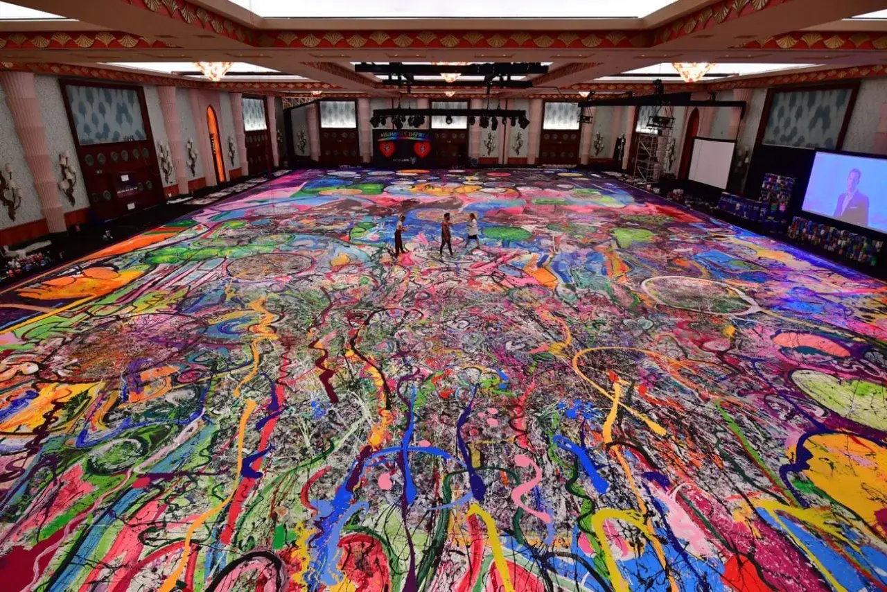 Un immense tableau, "la création du monde", recouvre le sol d'une salle. Des éclaboussures de peinture vives créent un chaos coloré, évoquant l'énergie primordiale.