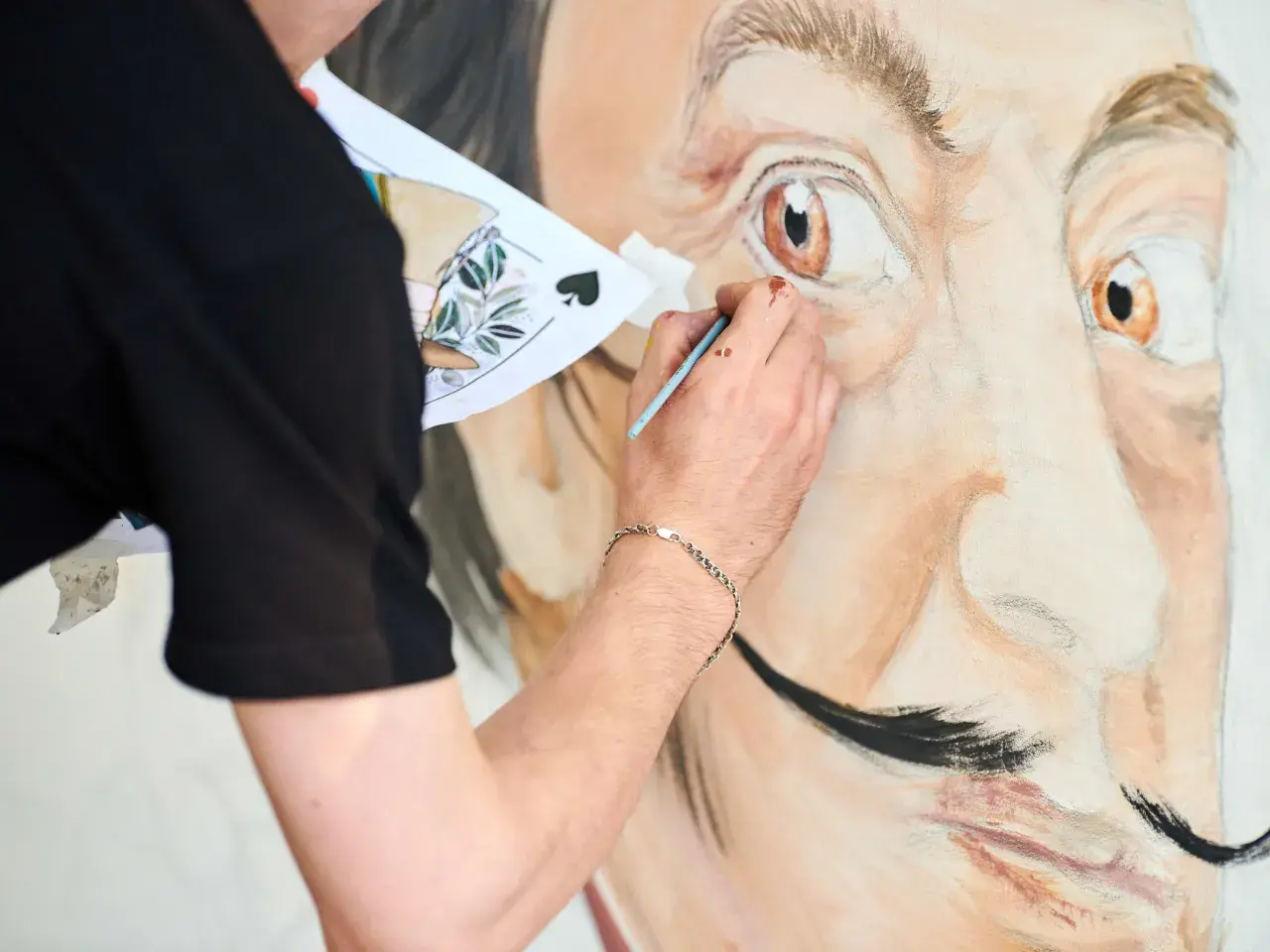 Un artiste peint le portrait de Salvador Dalí, expliquant pourquoi Salvador Dalí est connu pour son art surréaliste et son style unique.
