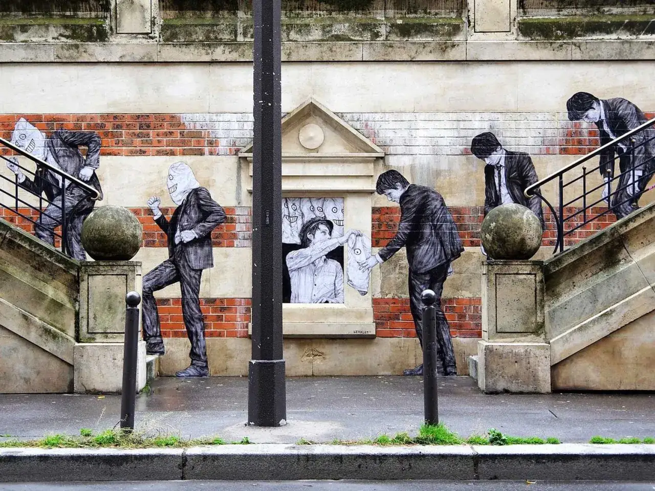 Un artiste street art dépeint des silhouettes en costume, certaines masquées, sur un mur parisien. Une scène surréaliste.