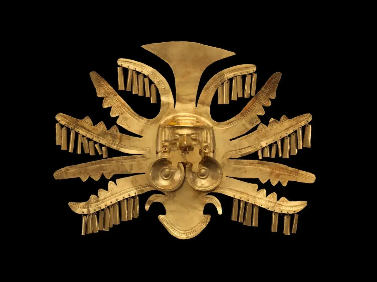 Masque d'or pr&eacute;colombien, un chef-d'&oelig;uvre d'art solaire, orn&eacute; de d&eacute;tails complexes et de pendeloques.
