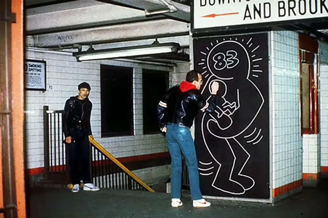 Œuvres d'art de Keith Haring dans le métro. Un homme admire une fresque emblématique.