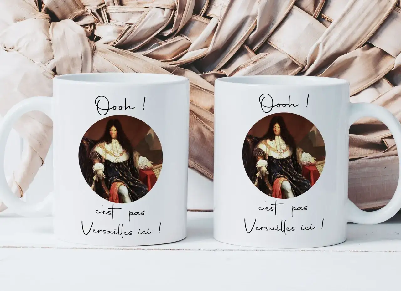 Deux tasses blanches avec un portrait de Louis XIV. L'une dit 