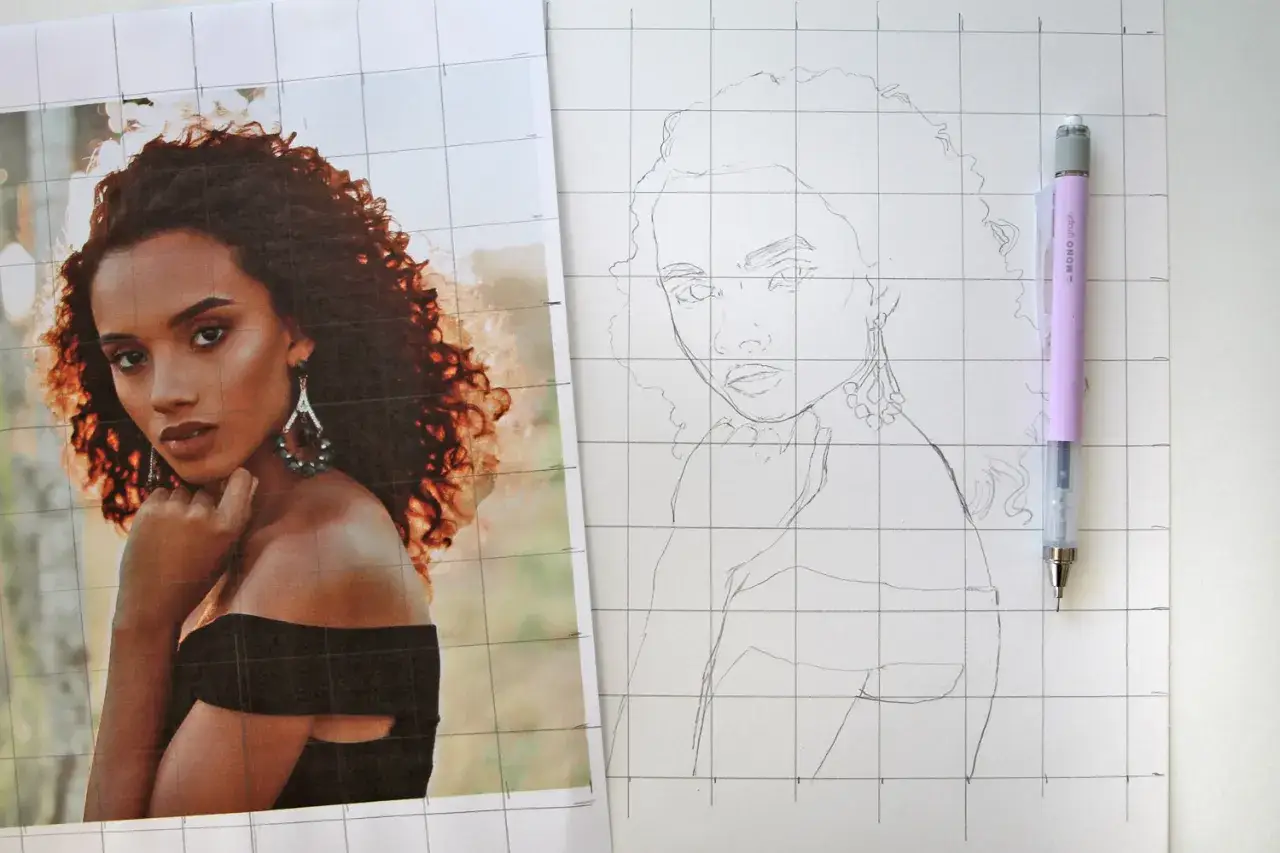 Une artiste dessine à partir d'une photo, utilisant une grille pour reproduire fidèlement les traits d'une femme aux cheveux bouclés et aux boucles d'oreilles scintillantes.