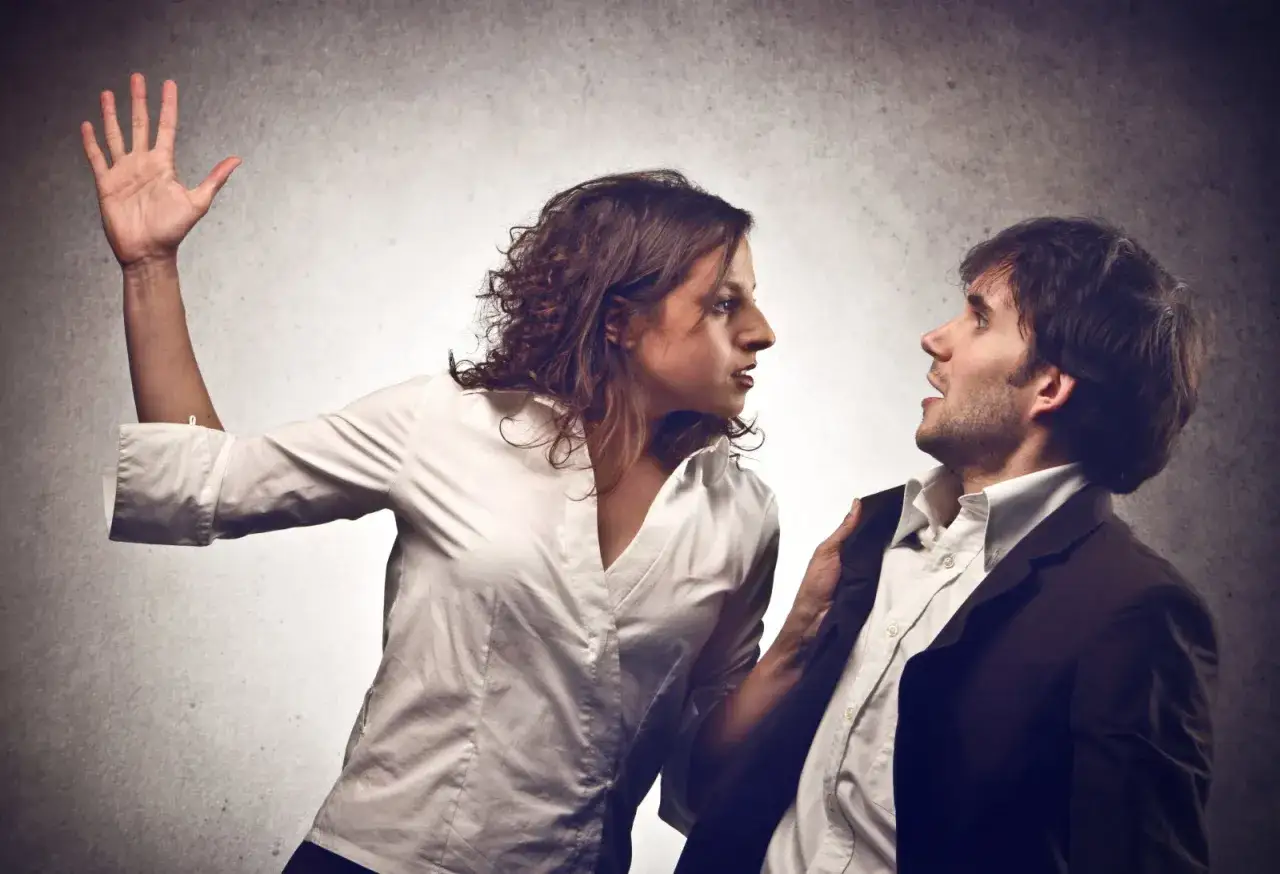 Une femme, visiblement énervée, s'apprête à péter un câble synonyme de colère. Elle tient la veste d'un homme qui semble surpris.