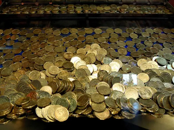 Un tas de pièces d'or, un véritable pactole, s'entassent dans une machine à sous, promettant fortune et gloire.