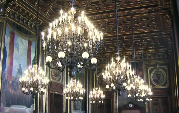 Lustres imposants illuminent une salle ornée d'une fresque monumentale. Ça fait des lustres que ce décor somptueux n'a pas été vu.